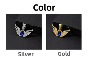 Detail view of angel wing pendants in silver and gold with blue sapphire stones