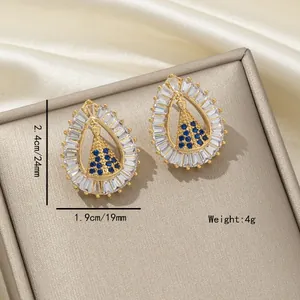 Gros plan de boucles d'oreilles gouttes avec cristaux bleus et strass blancs
