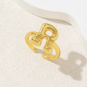 Anello dorato artistico con lettera R, design fluido lucido e fascia aperta regolabile