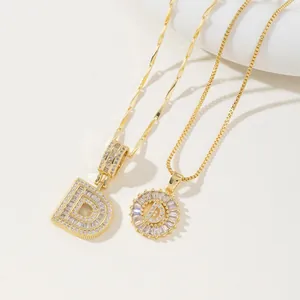 Detailed close-up of golden letter D pendants with shimmering zircon stones on chic chains