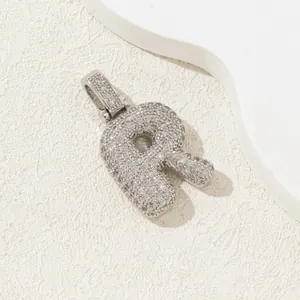 Vue détaillée du pendentif lettre R argenté serti de zircons au design bombé 3D
