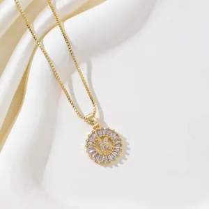 Macro shot of gold-plated letter K pendant with rectangular zircon and box chain