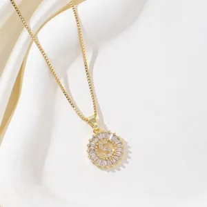 Close-up of golden letter S pendant with baguette-cut stones and box chain necklace