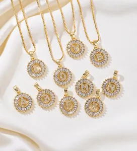 Macro shot of gold-plated circular pendants with zircon letters on white silk
