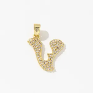 Macro shot of gold plated copper letter V pendant with micro paved cubic zirconia stones