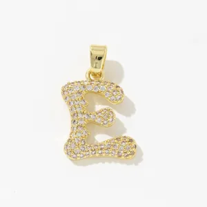 Detailed view of copper gold-plated letter E pendant with pavé set zircon crystals