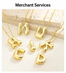 Macro shot of gold-plated 3D alphabet charms on bead chains over stone display