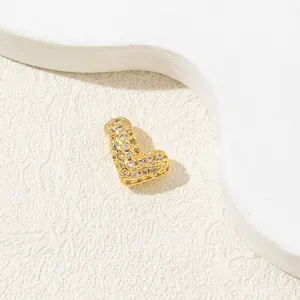 Macro detail of a 18K gold-plated heart-shaped letter L pendant with cubic zirconia