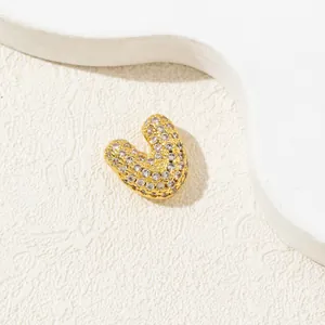 Macro shot of gold heart pendant with micro-pave white cubic zirconia on stone surface