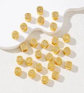 Detailansicht der vergoldeten Alphabet-Perlen mit Zirkonia-Inlay auf weißem Display