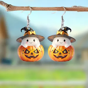 Macro-opname van schattige Halloween spook- en pompoen oorbellen hangend aan een tak