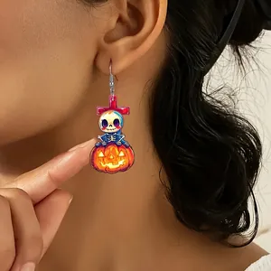 Schattige Halloween acryl oorbellen met schedel op pompoen gedragen door een model