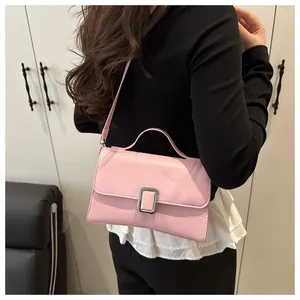 Vue détaillée du sac bandoulière rose en similicuir avec boucle argentée porté par un mannequin