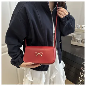 Dettaglio della borsa rossa con fibbia a fiocco dorato e texture in ecopelle fine