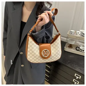 Détail du sac hobo rétro avec motif à lettres M et fermoir métallique doré
