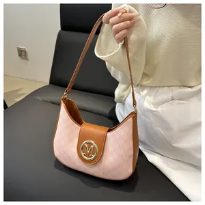 Vue détaillée du sac porté épaule rose avec logo M en métal et bandoulière en cuir marron
