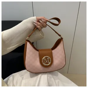 Détail du tissu à monogramme M rose et du rabat en cuir marron sur le sac d'épaule