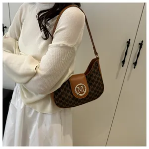 Détail du sac hobo vintage avec imprimé monogramme et boucle en métal doré