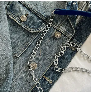 Details des silbernen Metallkettenriemens und der blauen Ledernaht an der Umhängetasche