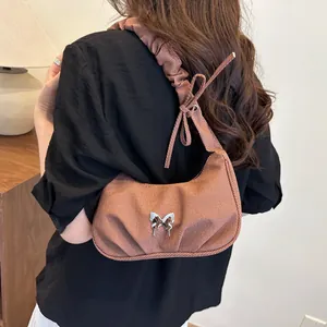 Brown vintage pleated cloud shoulder bag with silver butterfly accent on model