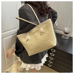 Detailed view of the V-shaped woven straw texture and stylish white shoulder strap knots