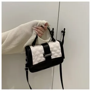 Détail du mini sac à main en cuir avec surpiqûres en losanges contrastées noir et blanc