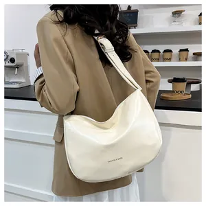 Side view of a creamy white hobo bag made of high-gloss PU leather with black lettering