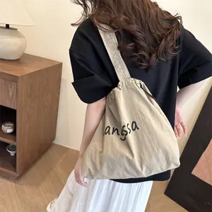 Minimalist beige canvas tote bag with black angsa lettering for daily casual shoulder wear