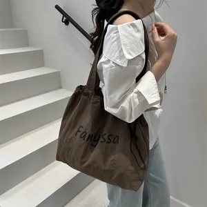 Dark brown nylon tote bag with drawstring and Fanyssa logo shown on a model
