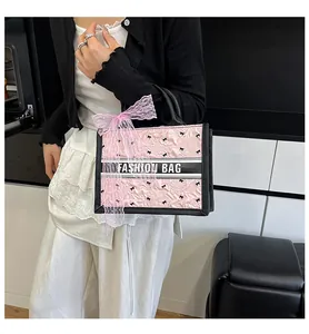 Detailed shot of pink tote bag featuring embossed bows and fashion ribbon handle