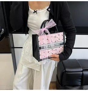 Detail of the pink satin tote with embroidery, large lace bow, and Fashion Bag strap