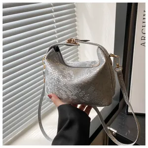 Bolso de mano gris plateado con piel de serpiente y detalles metálicos dorados