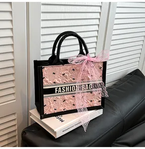 Close-up of pink pleated fabric tote bag with bow embroidery and silk ribbon detail