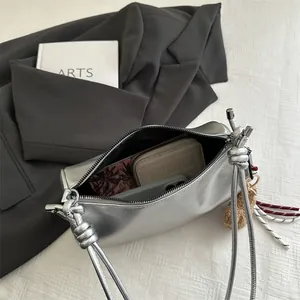 Silver metallic underarm pillow bag with tassel charm and internal storage view