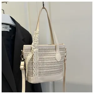 Detail of beige straw bucket bag with lace bow decoration and faux leather trim finish