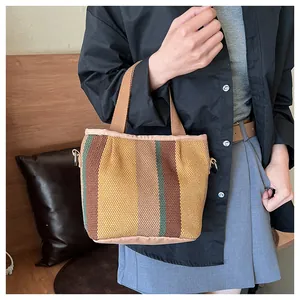 Détail du sac cabas tissé à rayures multicolores avec poignées en toile résistantes