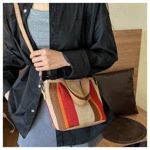 Détail du sac cabas tissé à rayures colorées avec texture rouge, orange et beige