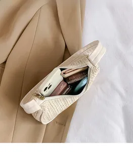 Detailed interior of woven shoulder bag showing storage for phone and cosmetics