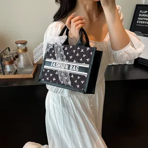 Fashionable black tote bag with white bow prints and large lace ribbon handle decoration