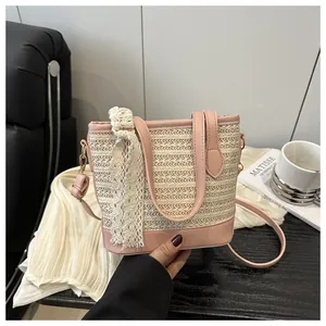Detail of pink straw bucket bag featuring lace bow and woven texture details