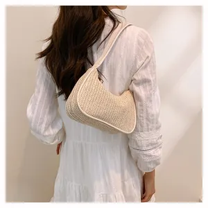 Close-up of woven straw texture and seamless piping on a beige crescent shoulder bag