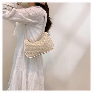 Detail of off-white woven straw hobo bag showing V-shape texture and minimalist design