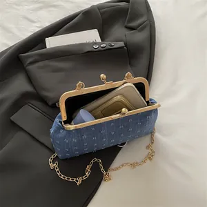 Sac à main en denim à pois avec chaîne dorée et fermoir à baiser montrant l'intérieur