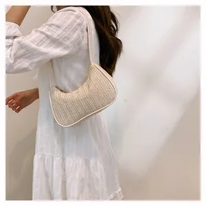 Close-up of a woven underarm bag with sleek leather trim and zipper detail for summer