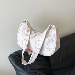 Minimalist white hobo bag with bamboo leaf print and sleek single shoulder strap