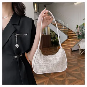 Detailed texture of white woven hobo bag with slim strap held by a model