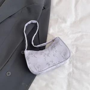Detail shot of lilac hobo bag with bamboo leaf print on textured fabric material