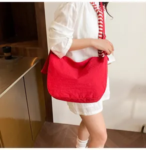 Makroaufnahme der roten gefalteten Hobo-Tasche mit breitem Schultergurt und weicher Textur