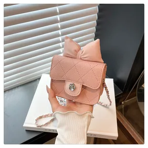 Pink quilted mini crossbody bag with a large leather bow and camellia metal buckle