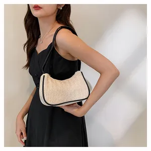 Fashionable beige woven shoulder bag styled with black dress and sleek strap